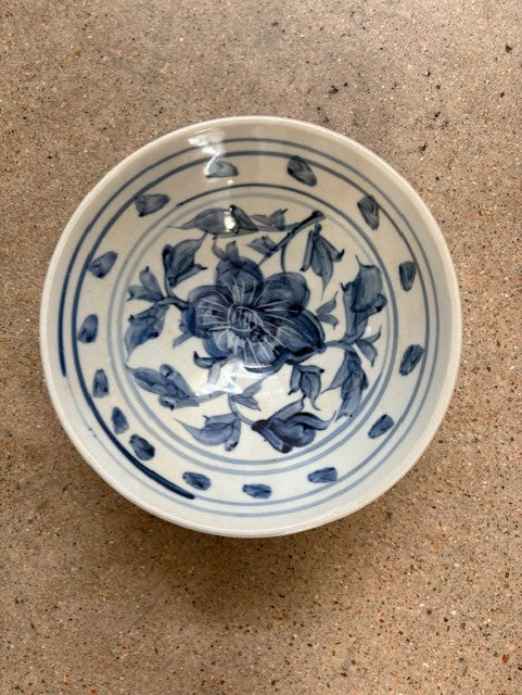Ceramic bowl with blue floral design on a beige surface