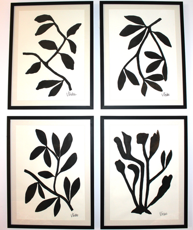 Four black and white wall art prints of leaf designs on a light background.