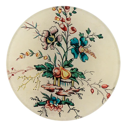 Round ceramic plate with floral and fruit design on a white background