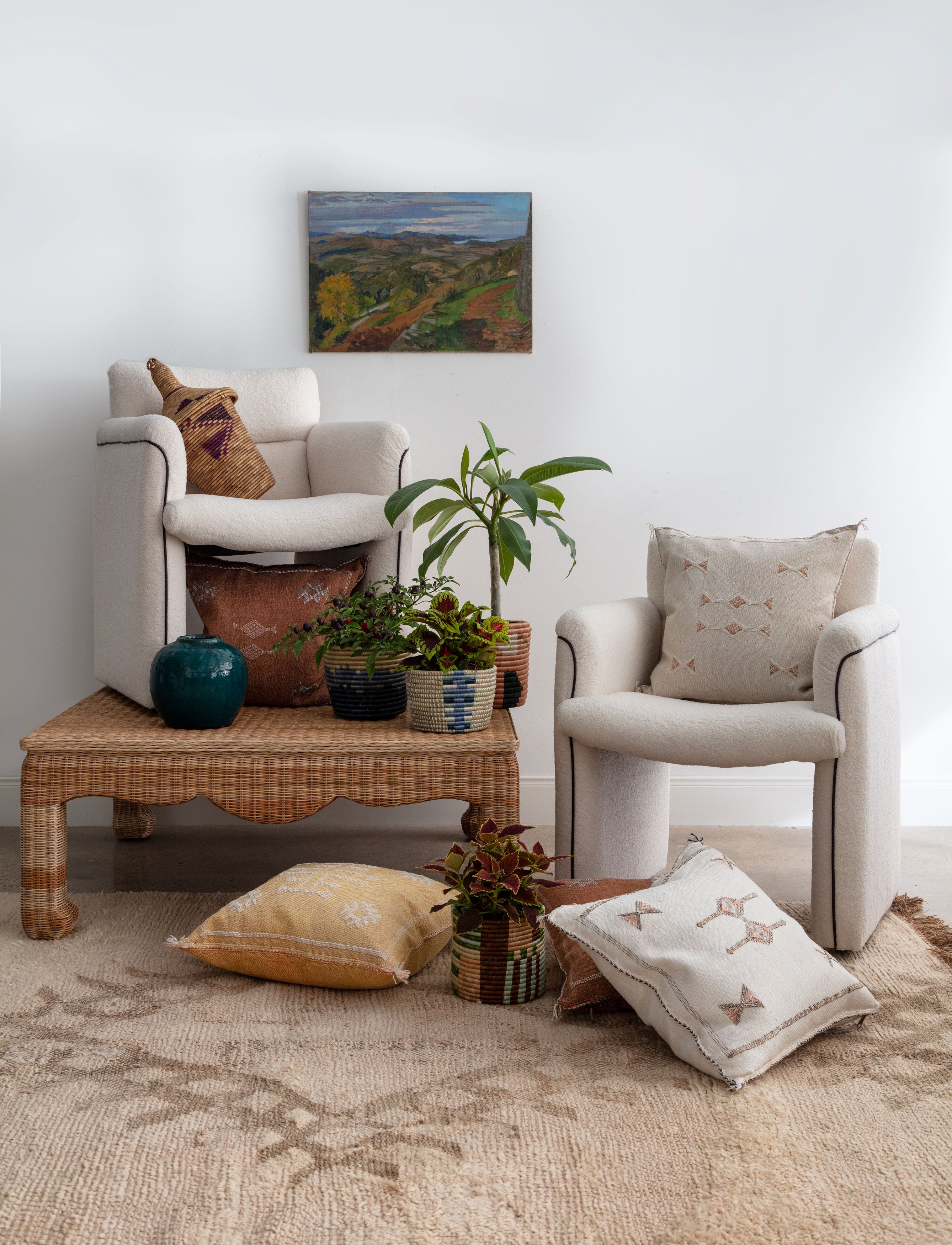 coffee table on moroccan rug with white boucle mid-century modern chairs