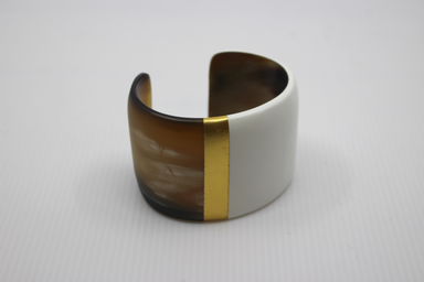Cuff bracelet with brown, white, and gold color scheme on a light gray background