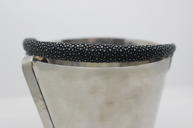 Metallic ice bucket with black textured rim on a light gray background