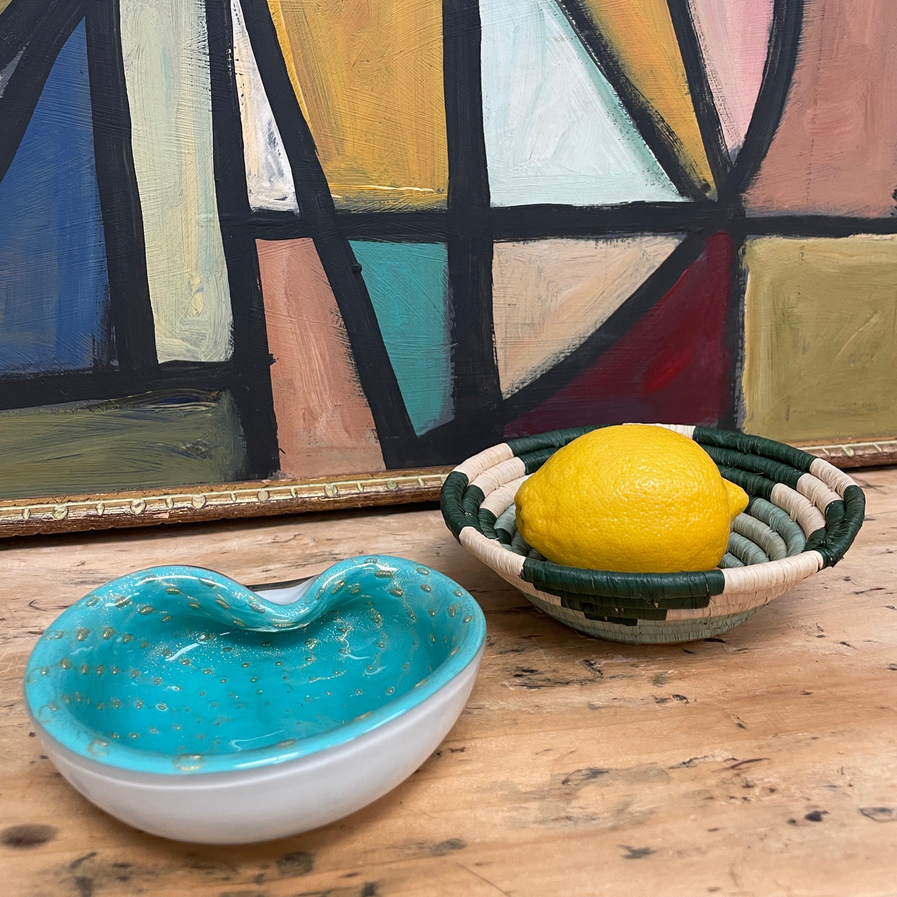 murano glass bowl and basket in front of painting