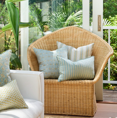 collection of pillows on rattan chair