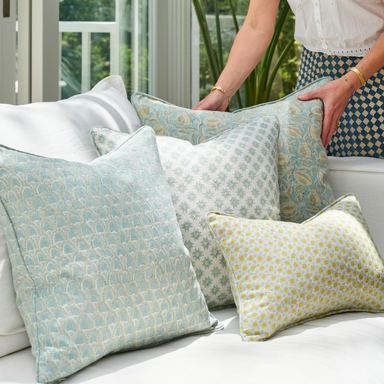 collection of pale blue patterned pillows on a white sofa