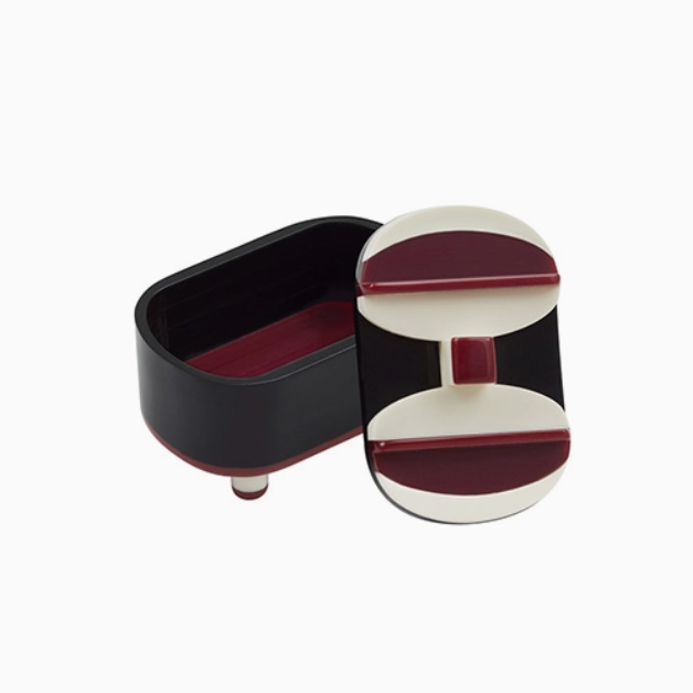 black, red, and white acrylic oval box with lid and ball feet