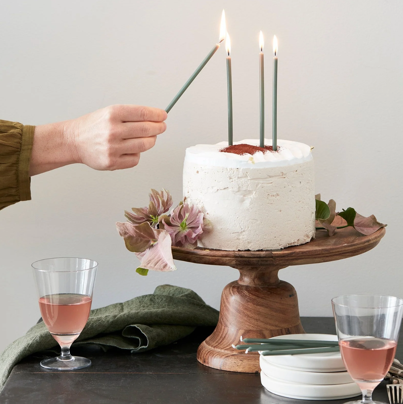 lit green candles on a white frosted cake