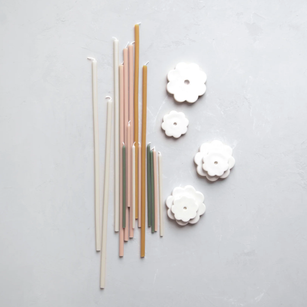collection of taper candles and flower-shaped candleholders