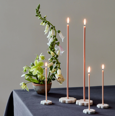 lit candles and candleholders on table wiht flowers