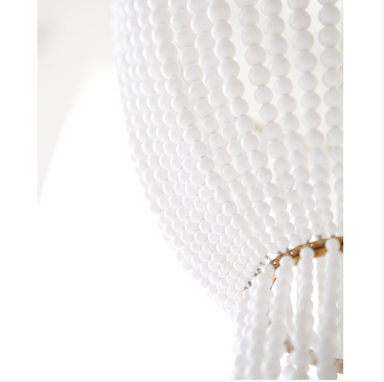 white bead and brass detail on chandelier