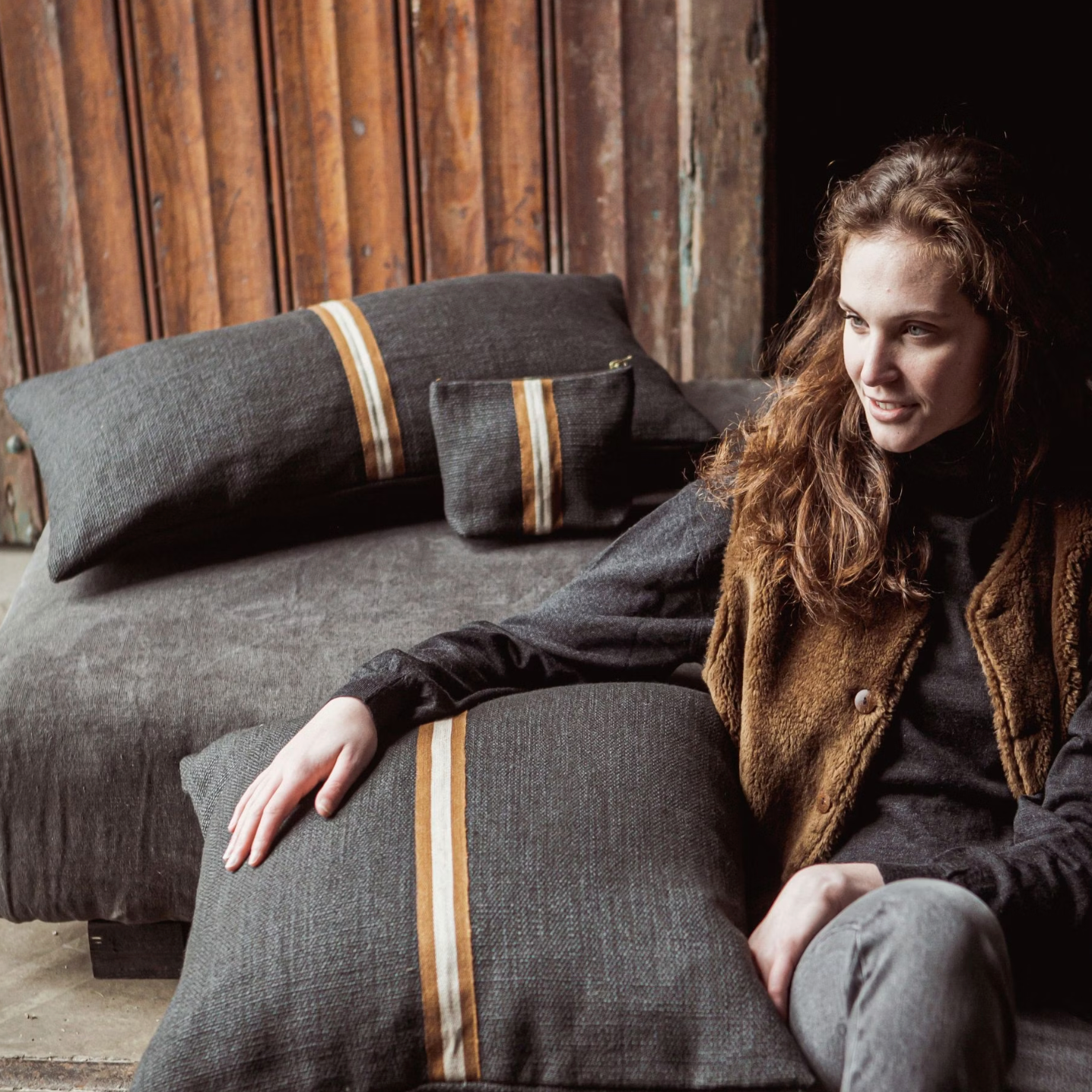 woman sitting with black linen pillows
