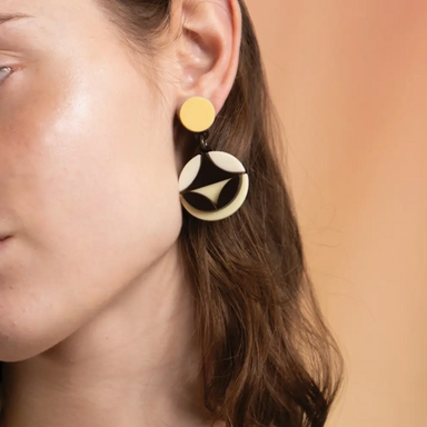 woman wearing a black, white and yellow acrylic earring