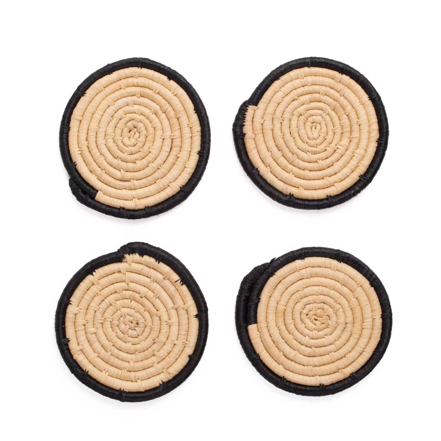 Four circular coasters with spiral pattern on a white background