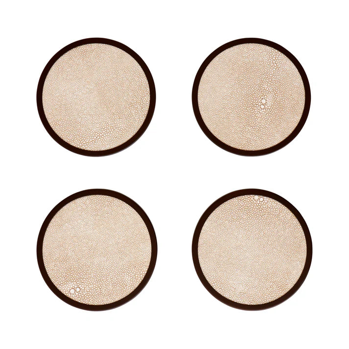 Four round beige coasters with brown rims on a white background