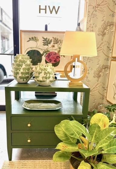 Green side table with decorative items in a room setting