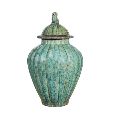 Green ceramic jar with a lion handled lid on a white background