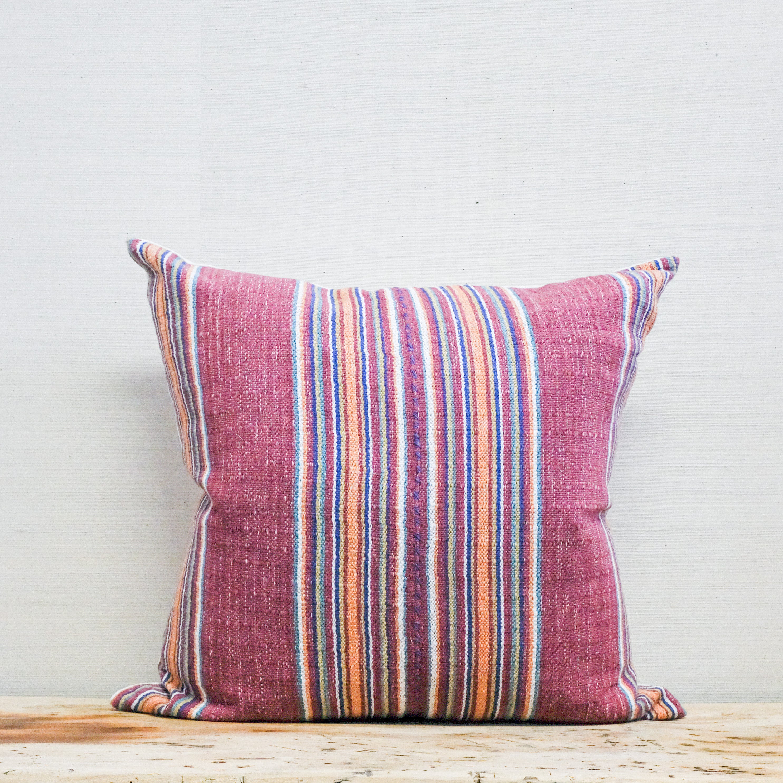 multi-color stripe textile on a square pillow