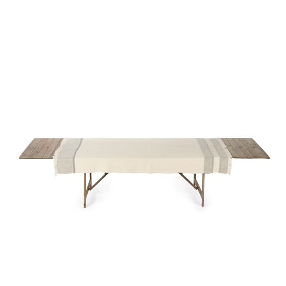 Long wooden table with a striped runner on a white background
