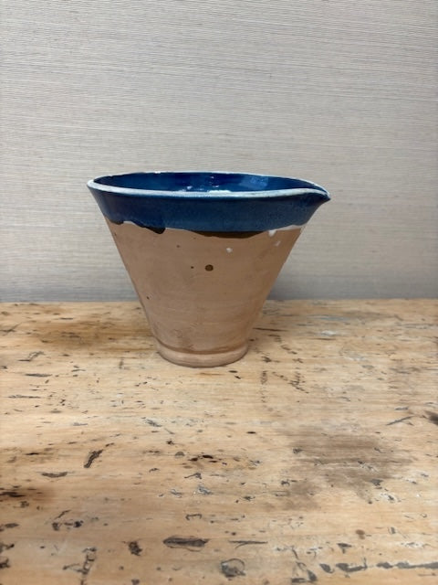Ceramic planter with blue rim on a wooden surface