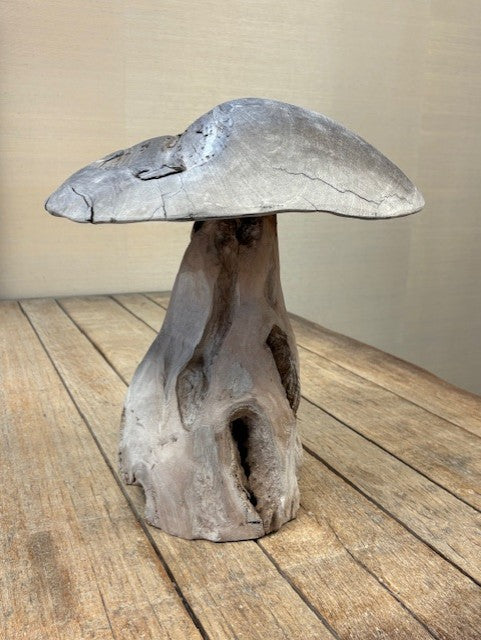 Mushroom-shaped decorative object on a wooden surface with a neutral background