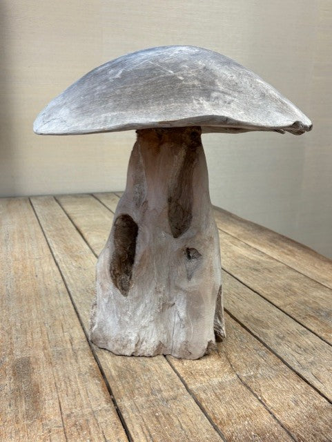 Decorative wooden mushroom on a wooden surface with a neutral background
