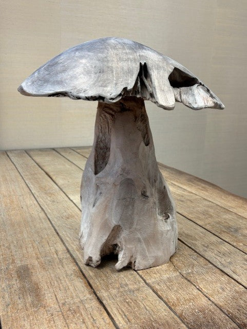 Wooden mushroom sculpture on a wooden surface with a neutral background