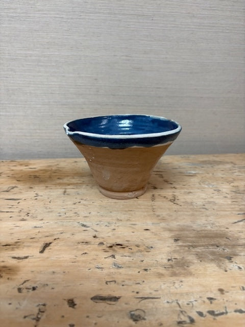 Ceramic bowl with blue interior on a wooden surface