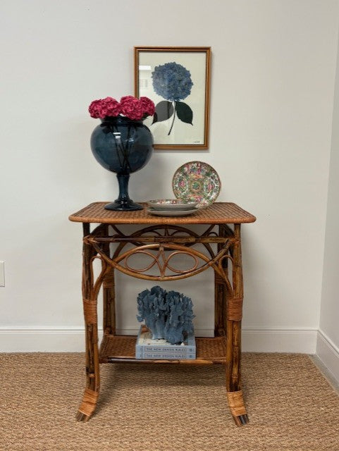 Wicker side table with decorative items against a white wall