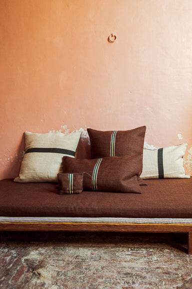 collection of pillows with center stirpe on day bed