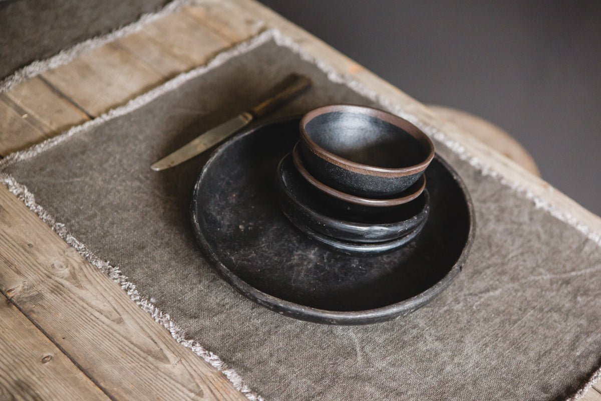 rustic pottery on linen placemat on wood table