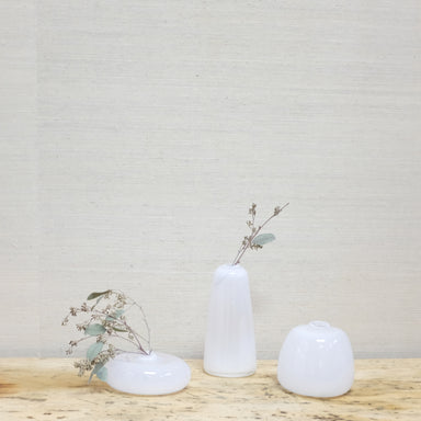 collection of white glass vases with dried eucalyptus