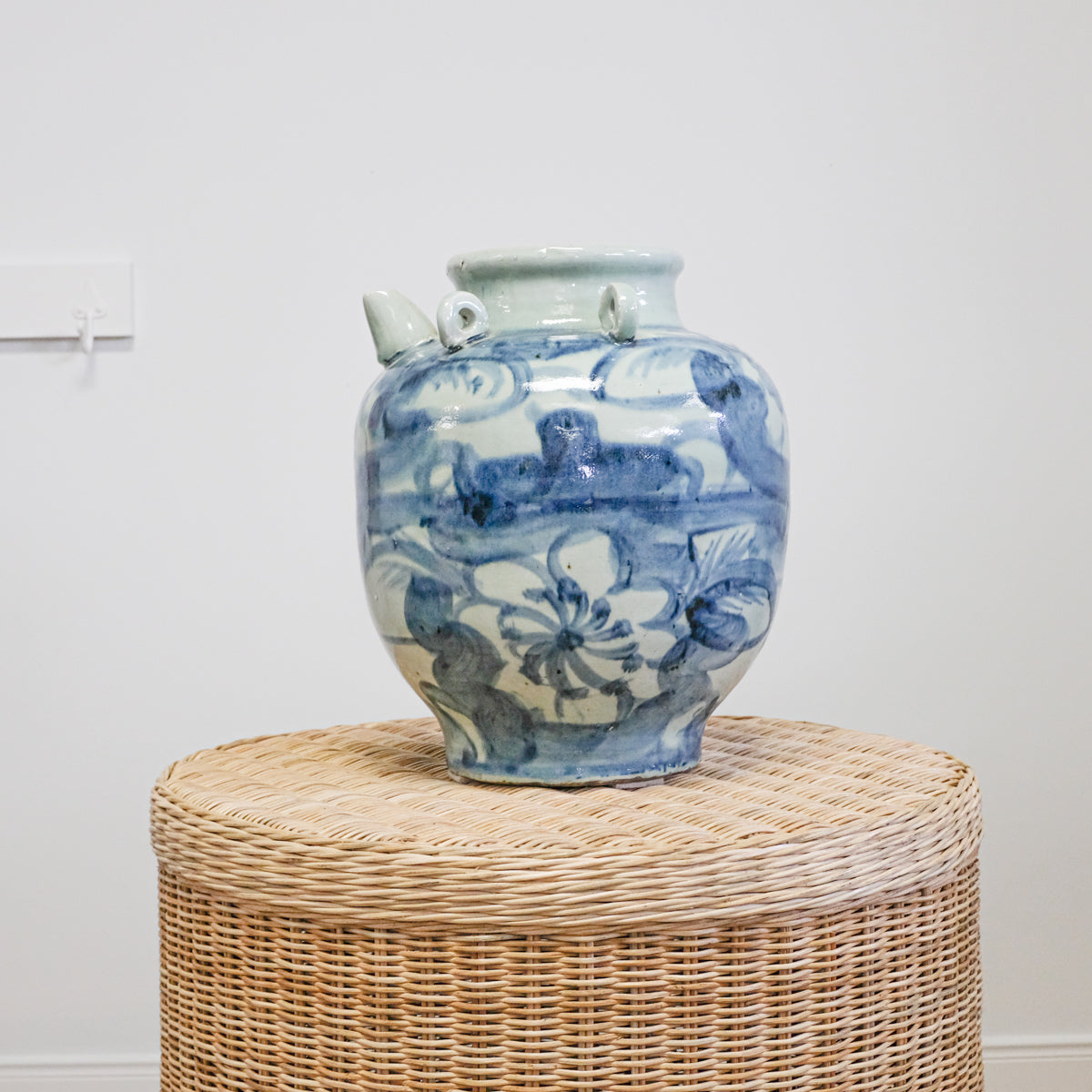 blue and white floral pottery jar on wicker table