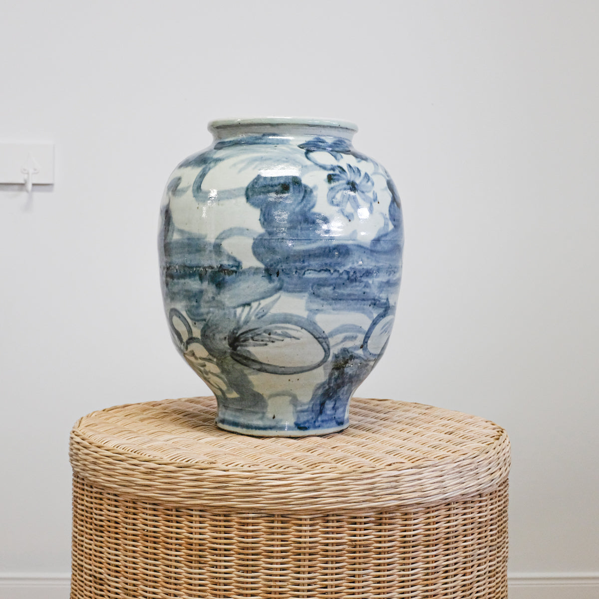 blue and white floral pottery on wicker table