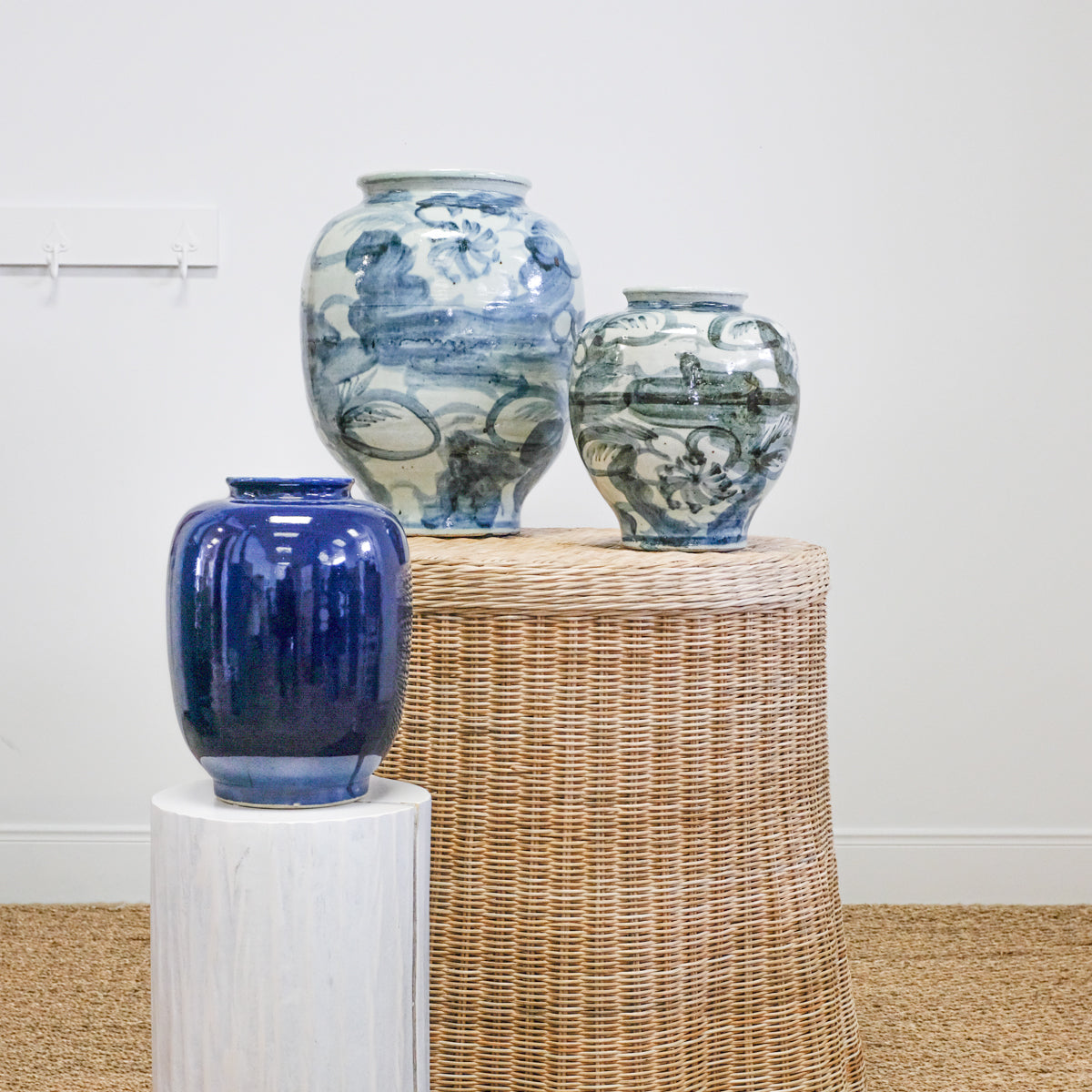 pottery jars on white pedestal and wicker table