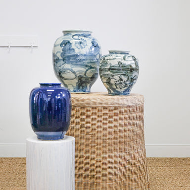 pottery jars on white pedestal and wicker table