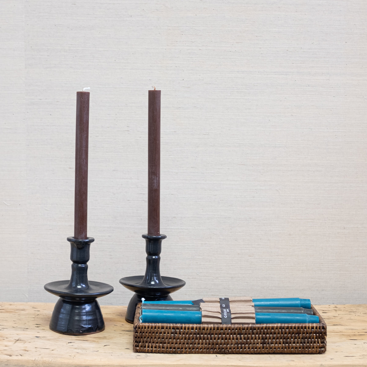 brown taper candles in black pottery candleholders
