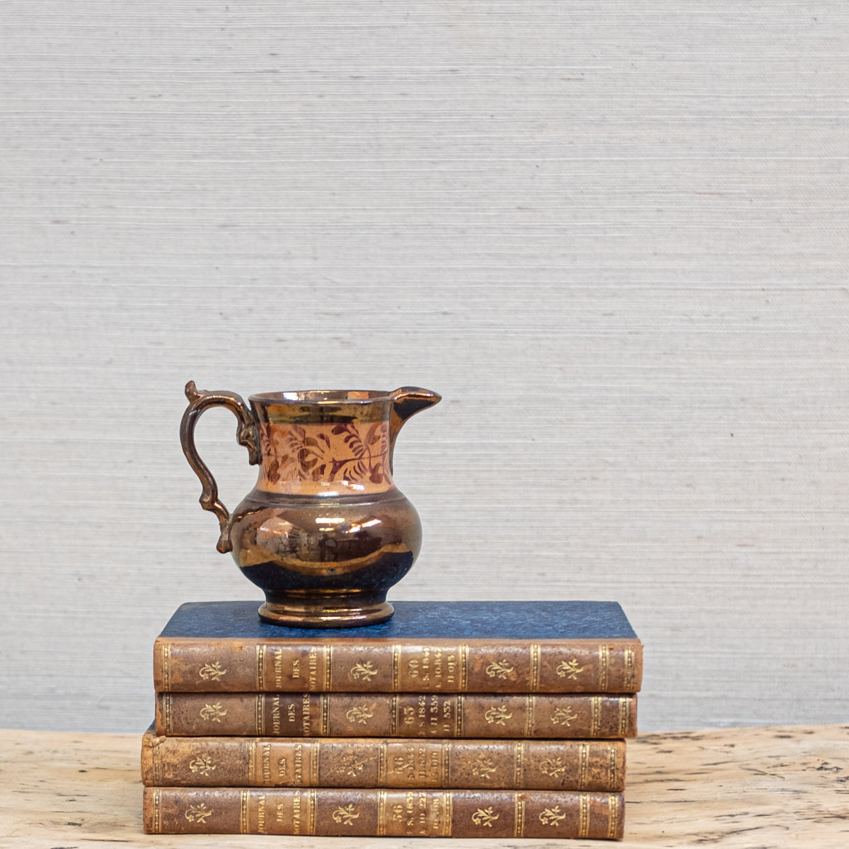 lusterware pitcher on stack of books