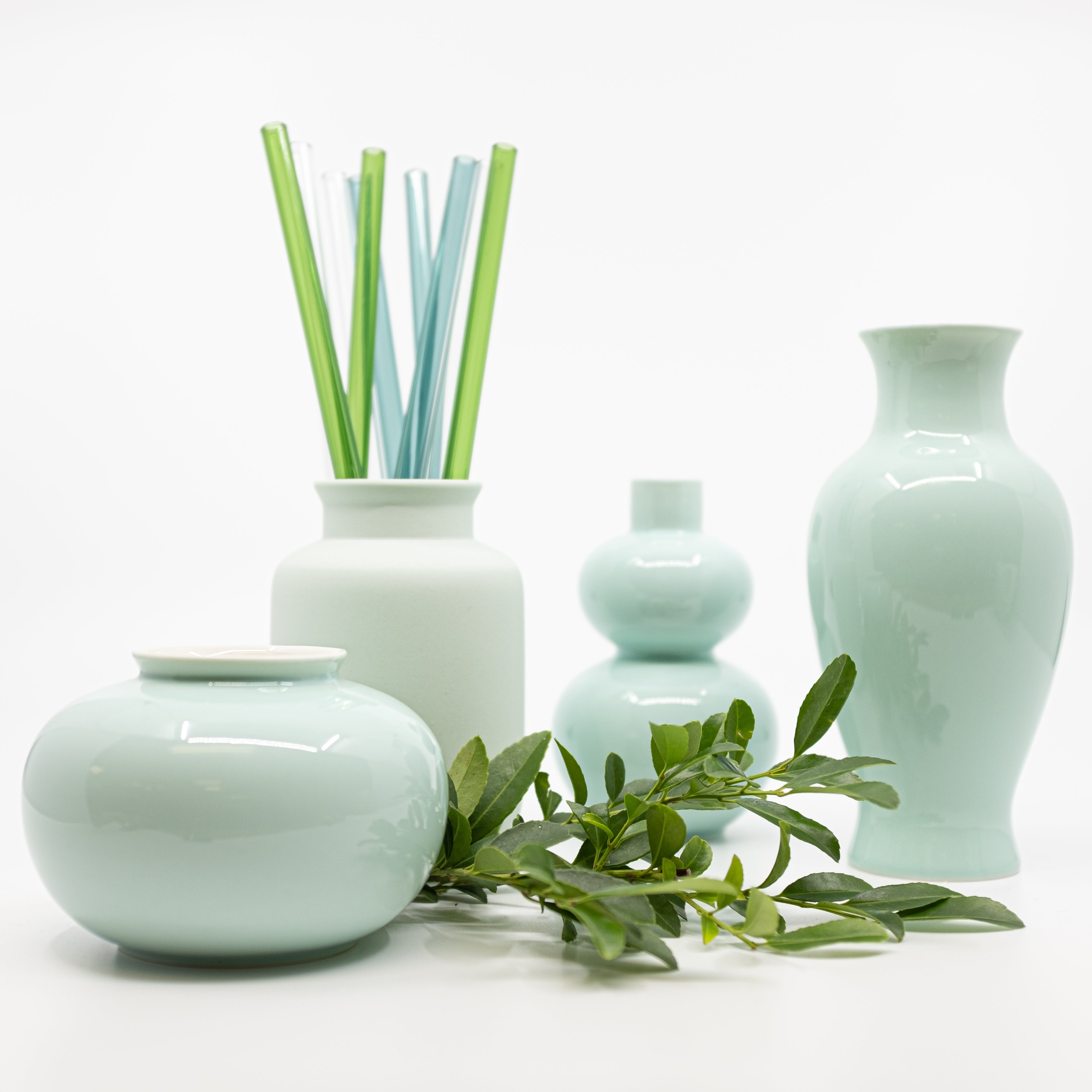 grouping of porcelain mini vases with glass straws in one