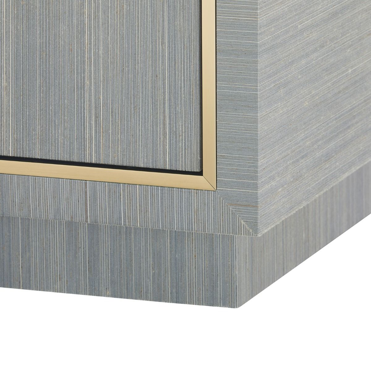 detail of recessed base and brass edging on a blue chest