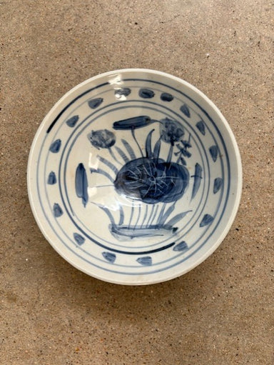 Ceramic bowl with blue floral design on a beige surface
