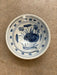 Ceramic bowl with blue floral design on a beige surface