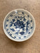 Ceramic bowl with blue floral design on a beige surface