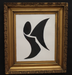 Framed artwork with a black abstract design on a white background