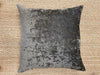 Textured dark brown pillow on a beige woven surface