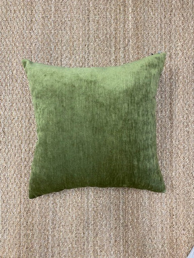 Green pillow on a textured beige surface