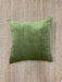Green pillow on a textured beige surface