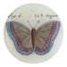 Butterfly illustration on a round ceramic tile with text