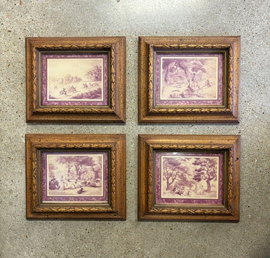 Four framed landscape art prints arranged in a 2x2 grid on a textured gray wall. Each print features a purple-toned scenic illustration with an ornate gold-toned frame.