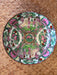 Decorative plate with colorful patterns on a woven surface