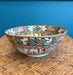 Decorative ceramic bowl with floral design on a woven surface with blue background